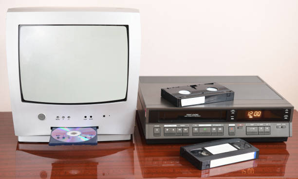 An old silver TV with built-in DVD player and a vintage VCR from the 1980s, 1990s, 2000s next to it. An old silver TV with built-in DVD player and a vintage VCR from the 1980s, 1990s, 2000s next to it. dvd player stock pictures, royalty-free photos & images