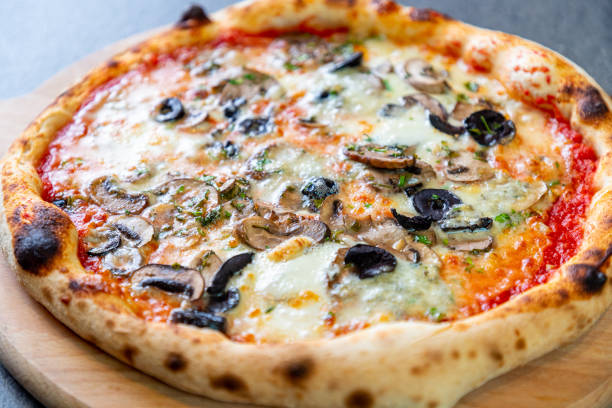 pizza con mozzarella, funghi a fette e olive nere su tavola di legno - edible mushroom portion chopped freshness foto e immagini stock