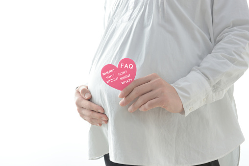 Pregnant woman having heart object with question mark on white background
