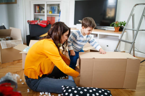 istock Mother making a tunnel from an empty cardboard box for her toddler to play 1296453028