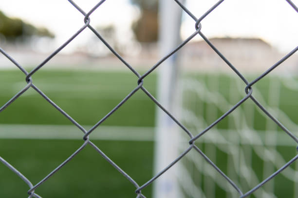 istock Empty soccer field closed with a metal fence 1296453146