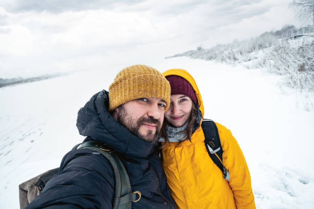 istock Happy couple taking selfie outdoors. Winter landscape on background. 1296456411