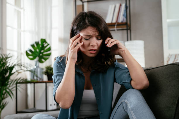 istock Sad woman sitting on the couch, using the phone. 1296457723