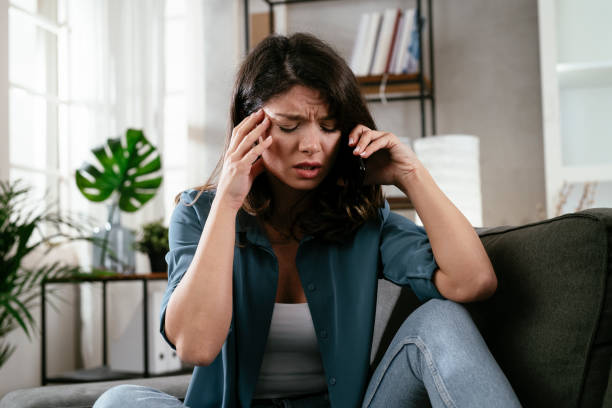istock Sad woman sitting on the couch, using the phone. 1296457990
