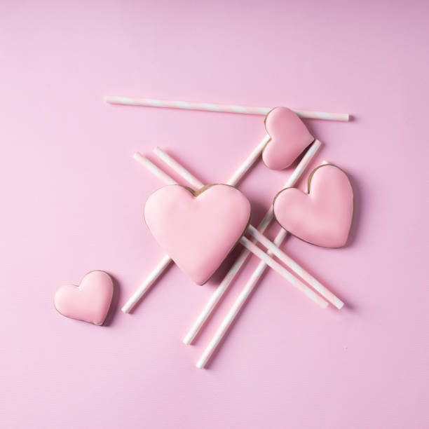 istock Creative layout made with heart shaped cookies and straws on pastel pink background 1296458090