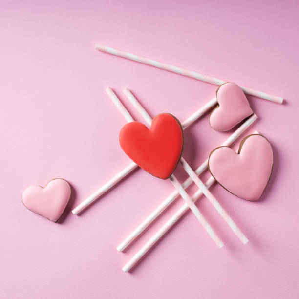 istock Creative layout made with heart shaped cookies and straws on pastel pink background 1296458794