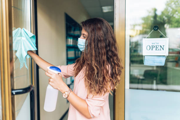 istock Woman disinfecting the store before reopening 1296458990