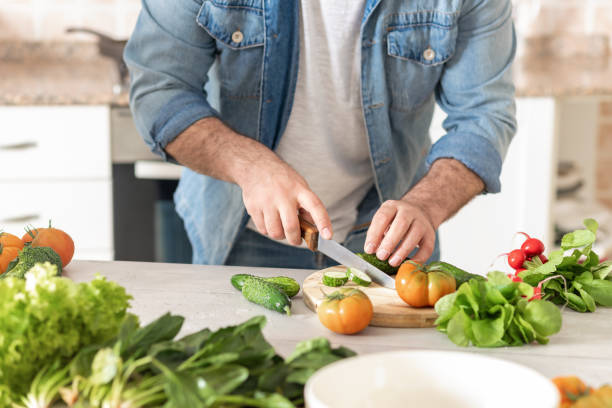 istock Man preparing delicious and healthy lunch home kitchen 1296462986
