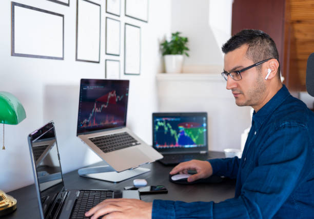 junge investor mann analysiert aktienmarkt mit charts auf laptop-computer-bildschirm im home-office. börse, investitionen, kryptowährungen und finanzhandel mit online-geschäft. - börsenhändler stock-fotos und bilder