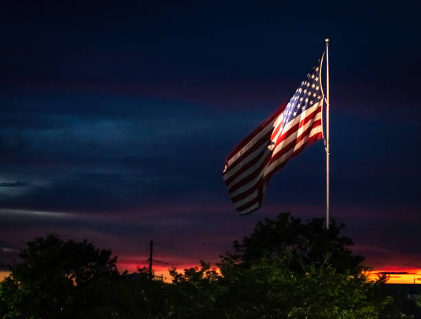 istock American flag in front of a brilliant sunset 1296464792
