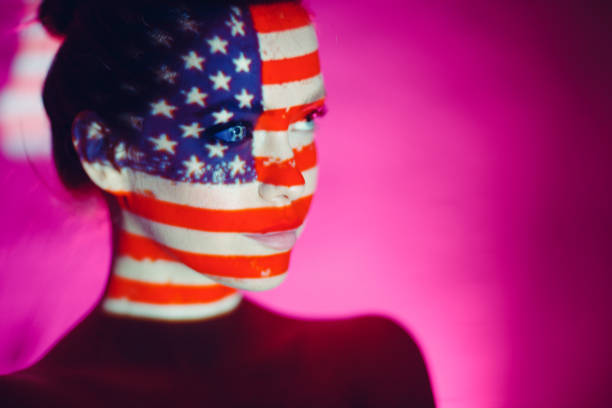 istock Young woman with USA flag on her face 1296465055