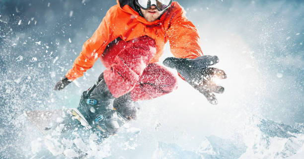 snowboarder saltando pelo ar com céu azul profundo no fundo. o esportista de snowboard voando em ação de neve e movimento - skiing snowboarding snowboard snow - fotografias e filmes do acervo