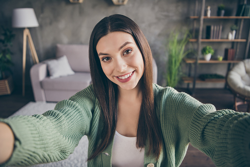 Portrait of optimistic girl doing selfie from home wear green shirt indoors.
