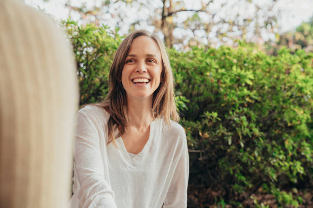 istock Woman smiling while talking to a friend 1296468256