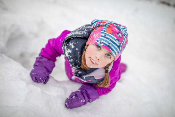 Girl Wearing Pink Winter Overall Having Fun On The Snow