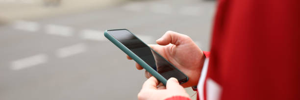 istock Man stands at crossroads with phone in his hands 1296470772
