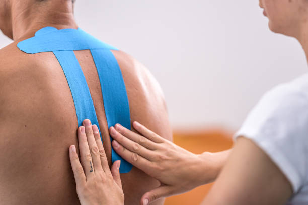 istock Woman taping client's back for prevention or treatment 1296471628
