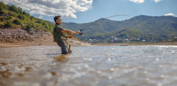 istock Fisherman pulling a fish with a fishing rod on a lake in Mavrovo 1296473634