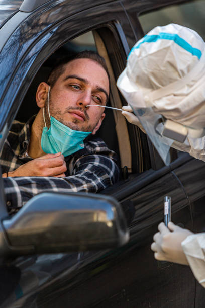 istock Medical worker in PPE performing drive-thru COVID-19 test 1296478936