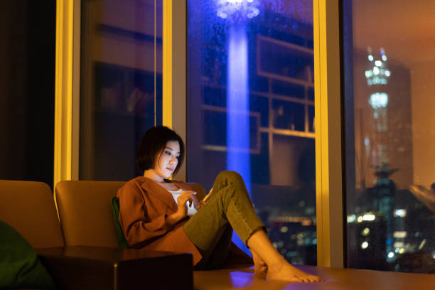 istock Beautiful Asian woman using smartphone at night 1296479041