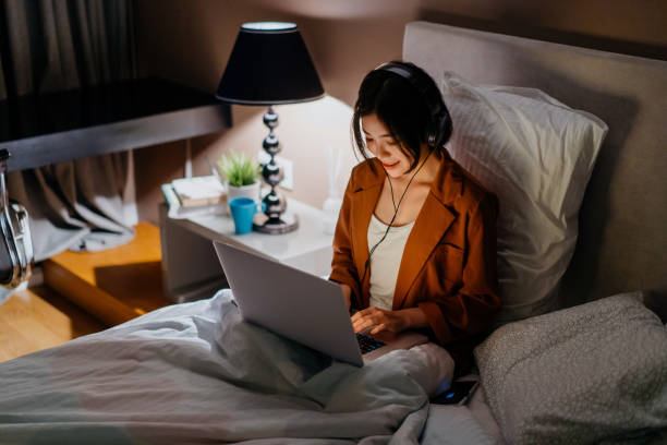 istock Young asian woman using laptop in bed 1296479044