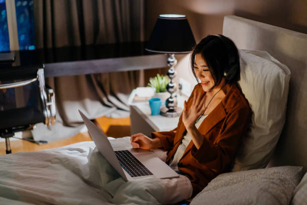 istock Young asian woman video calling in bed 1296479137