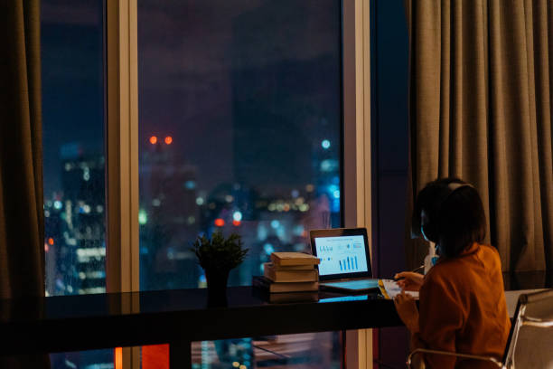 istock Young woman working late at home 1296479600