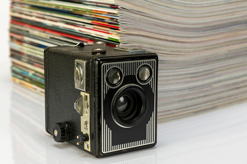 Antique cameras and magazines against a white background.