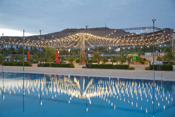 istock Beautiful view of Infinity Swimming Pool . cloud reflections on the infinity pool . Blurred of restaurant with light gold in night . The reflection of the clouds falls into the pool. 1296482940