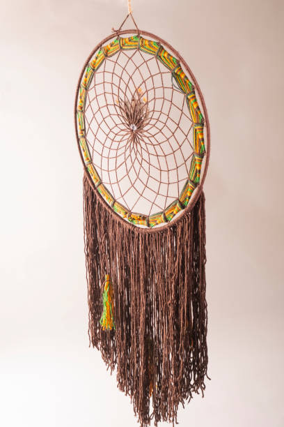istock dream catcher made of yellow and green strings pulled in the studio 1296483813
