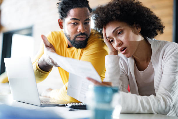 giovane coppia nera che ha problemi con l'online banking a casa. - home finances couple computer african ethnicity foto e immagini stock