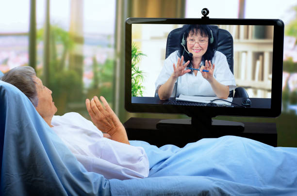 A gerontologist communicates in real time with a quarantine elderly patient. stock photo