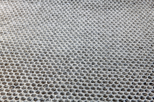 Wind protection: metal mesh with corrugated board on the background of the road.