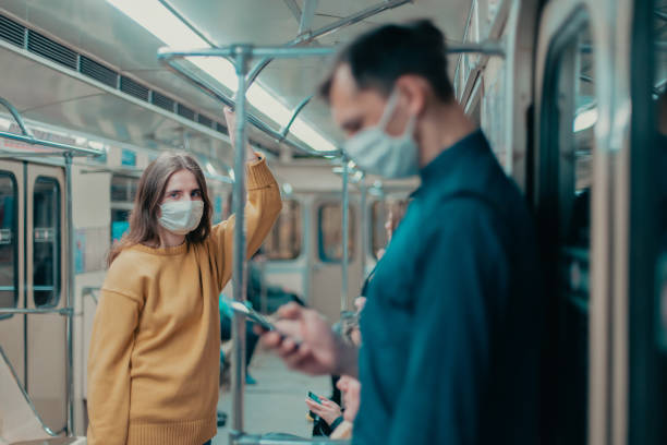 istock young woman in a protective mask standing in a subway car 1296497817