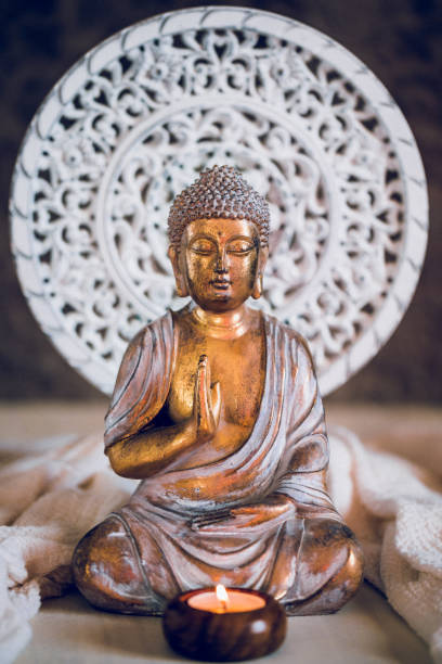 istock Golden Buddha with a candle in the foreground 1296499015