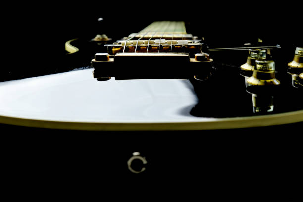 A six string bass guitar leaning against an amplifier, isolated on a white background.