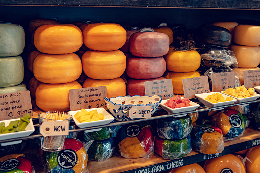 Gouda, Netherlands - July 20, 2020: many different kinds large delicious hunks of cheese on the shelves on sale in a Cheese shop in Gouda
