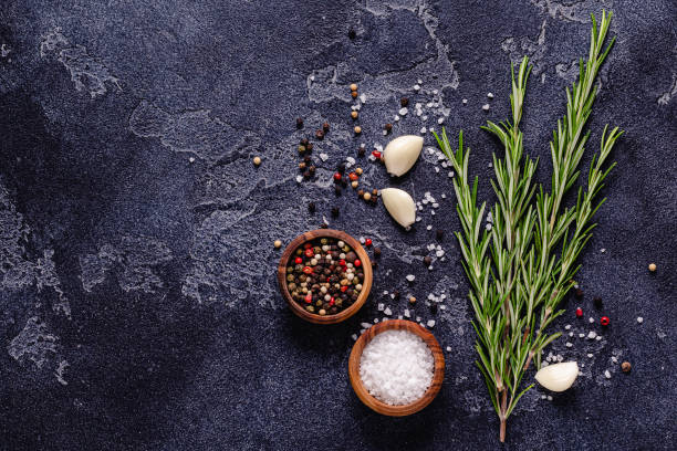 istock Herbs and condiments on black stone background 1296502142