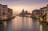 Sunrise colors of Grand Canal and Basilica di Santa Maria della Salute, very long exposure view from Accademia bridge, Venice, Italy