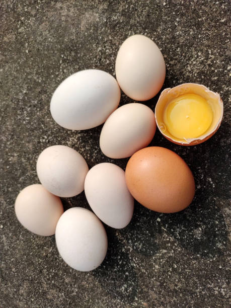 яичный фон. куча золотых и белых яиц на текстуре фона. вертикул яйцо фон. - protein isolated shell food стоковые фото и изображения