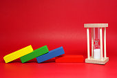 Domino crash fall effect with Sand clock on red background , The impact of financial status and inflation or from viruses covid-19 - countdown business economic problems - don't have time - Loss