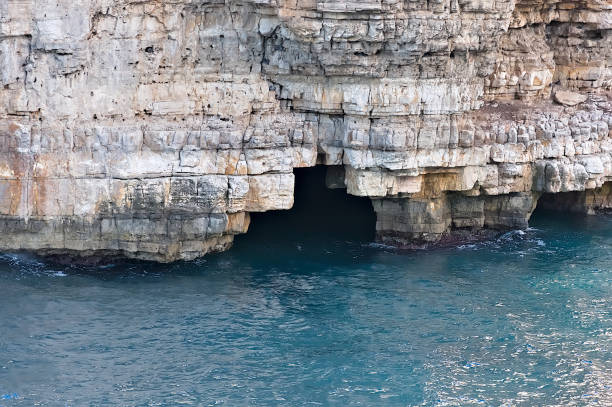 polignano a mare, a beautiful Italian tourist destination in Puglia. Detail of the rocky coast overlooking the sea with its caves