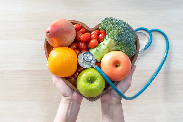 營養學家和醫生推薦營養品在心臟菜中吃乾淨的水果和蔬菜，以膽固醇飲食和健康營養飲食促進心臟健康，促進患者健康 - 健康的生活方式 個照片及圖片檔