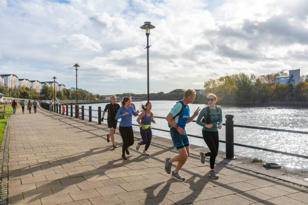 Runners on the Quayside near the Ouseburn with a line of town houses in the background of this up and coming area. Newcastle-upon-Tyne, UK.