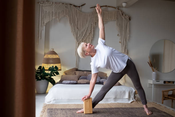 istock Senior woman practicing yoga, stretching in Utthita Trikonasana exercise, extended triangle pose 1296511637