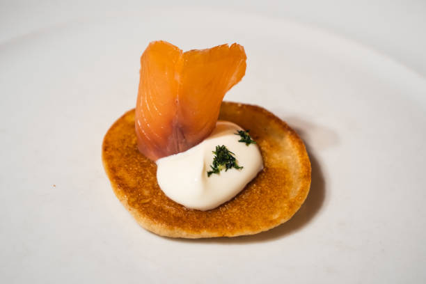 istock Salmon Blini garnished with Sour Cream on a White Plate 1296512188