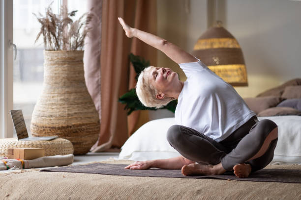 istock Mature Woman doing stretching yoga side bend 1296512817