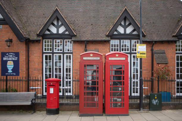 Stratford upon Avon, UK - April 30, 2018: Two red telephone booths and  a post box on the downtown street.