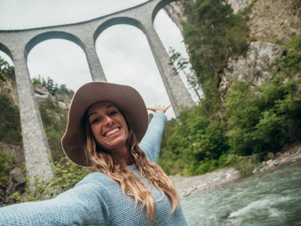 istock Woman takes selfie at famous viaduct, low angle view 1296512929