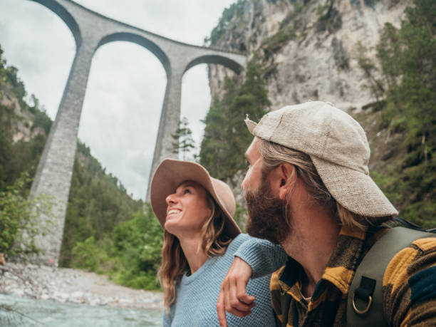 istock Couple contemplate viaduct from the river below, Switzerland 1296514248
